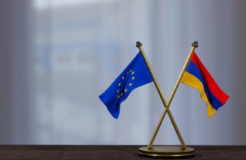 Флаг ЕС и Армении на фоне здания Европейской комиссии в Брюсселе
